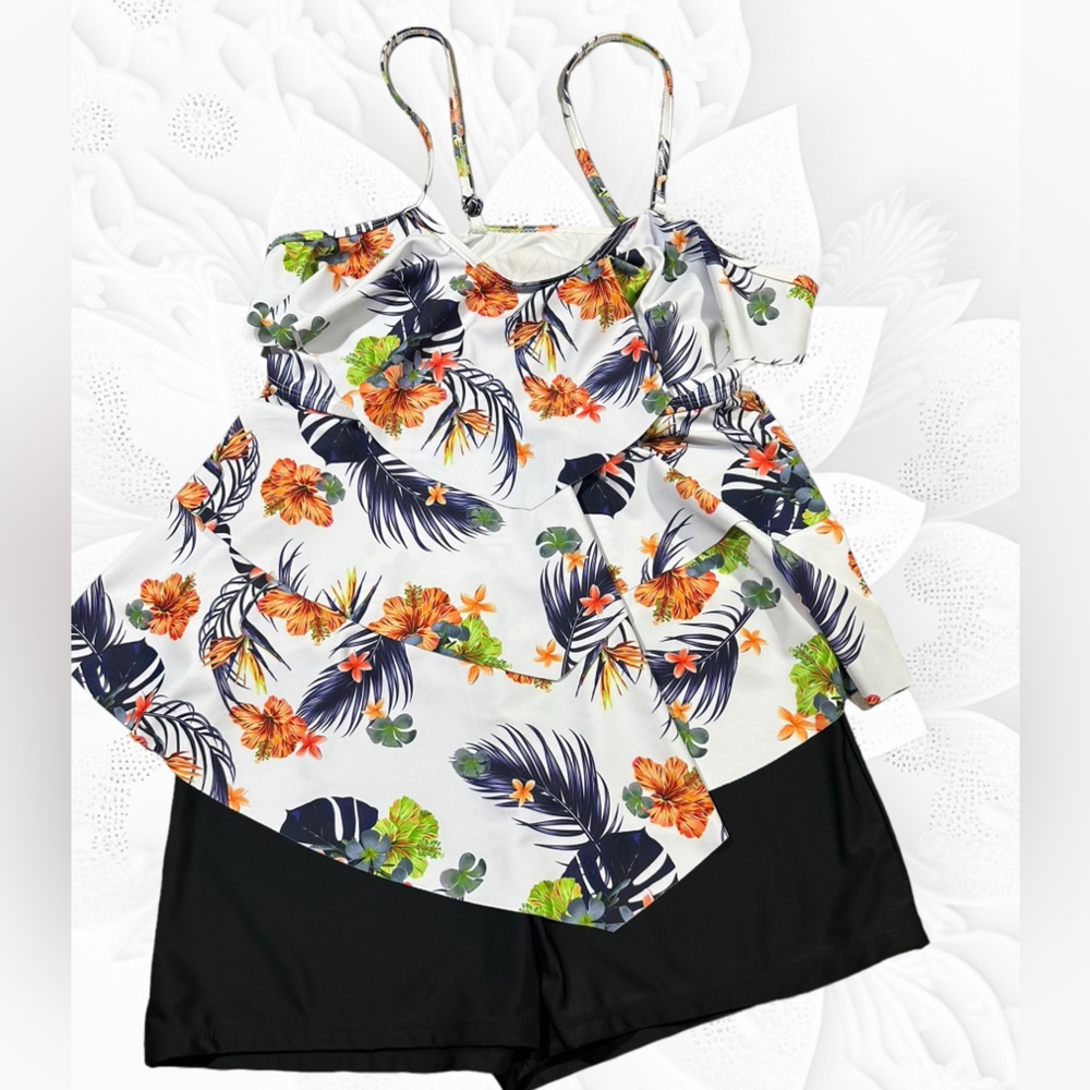Three tiered tankini set. White top with tropical print and black boy shorts.